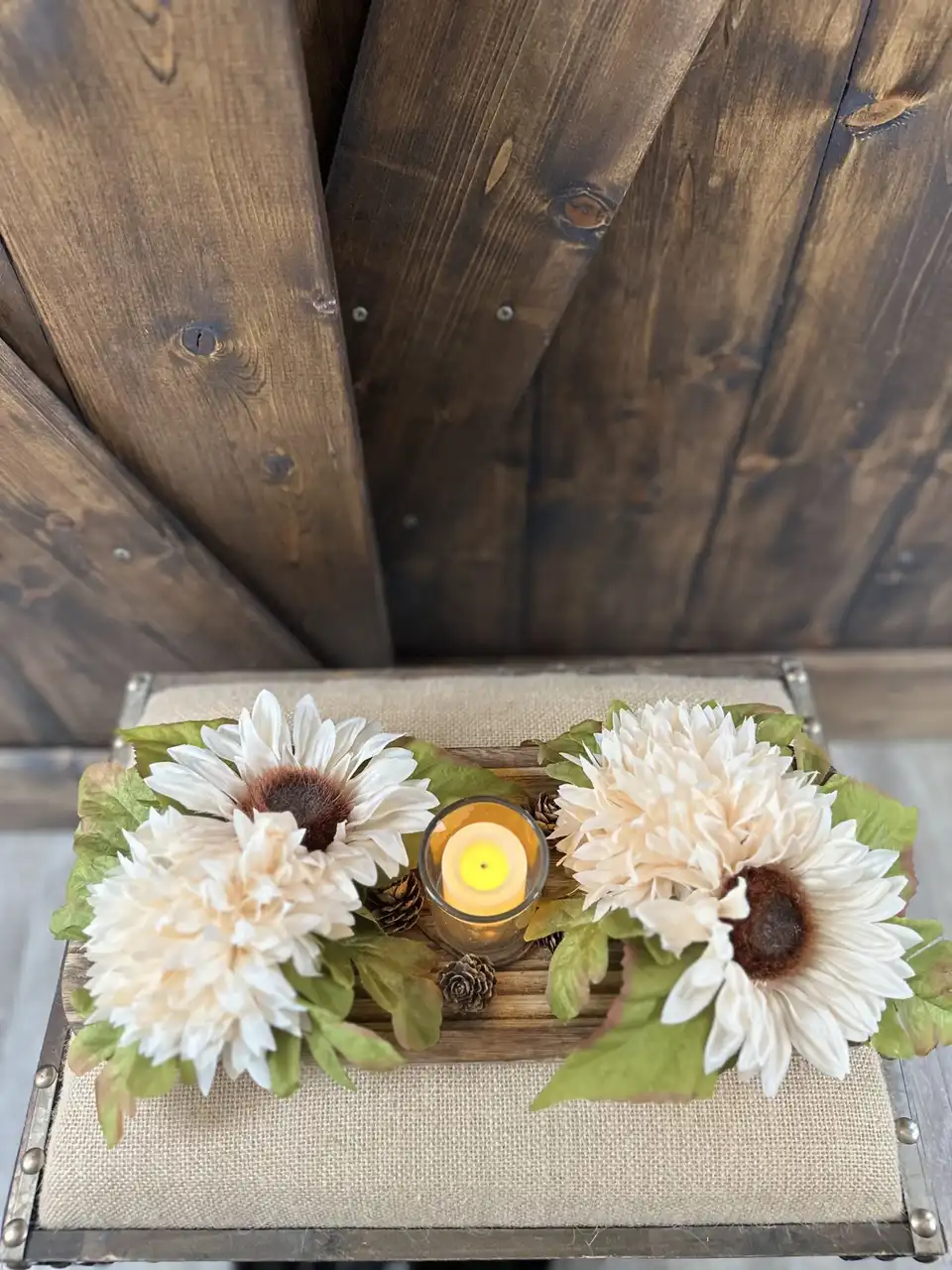 Cream sunflower centerpiece on a wood tray with a flickering pillar candle